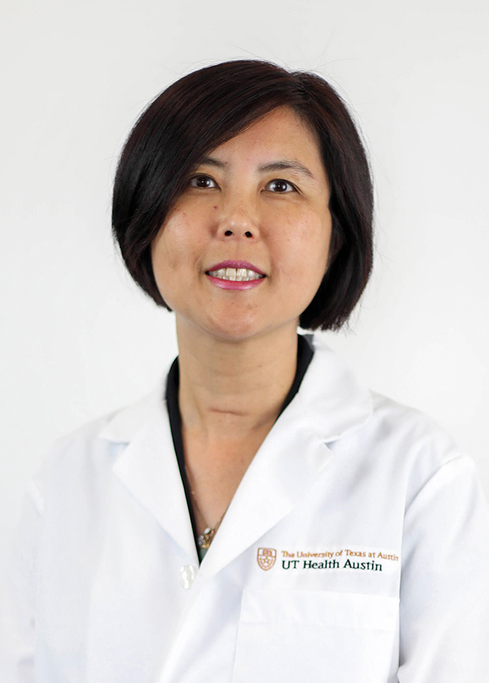 Reproductive endocrinologist and infertility specialist Winifred Mak, MD, PhD, wearing a white coat and smiling in front of a white backdrop.