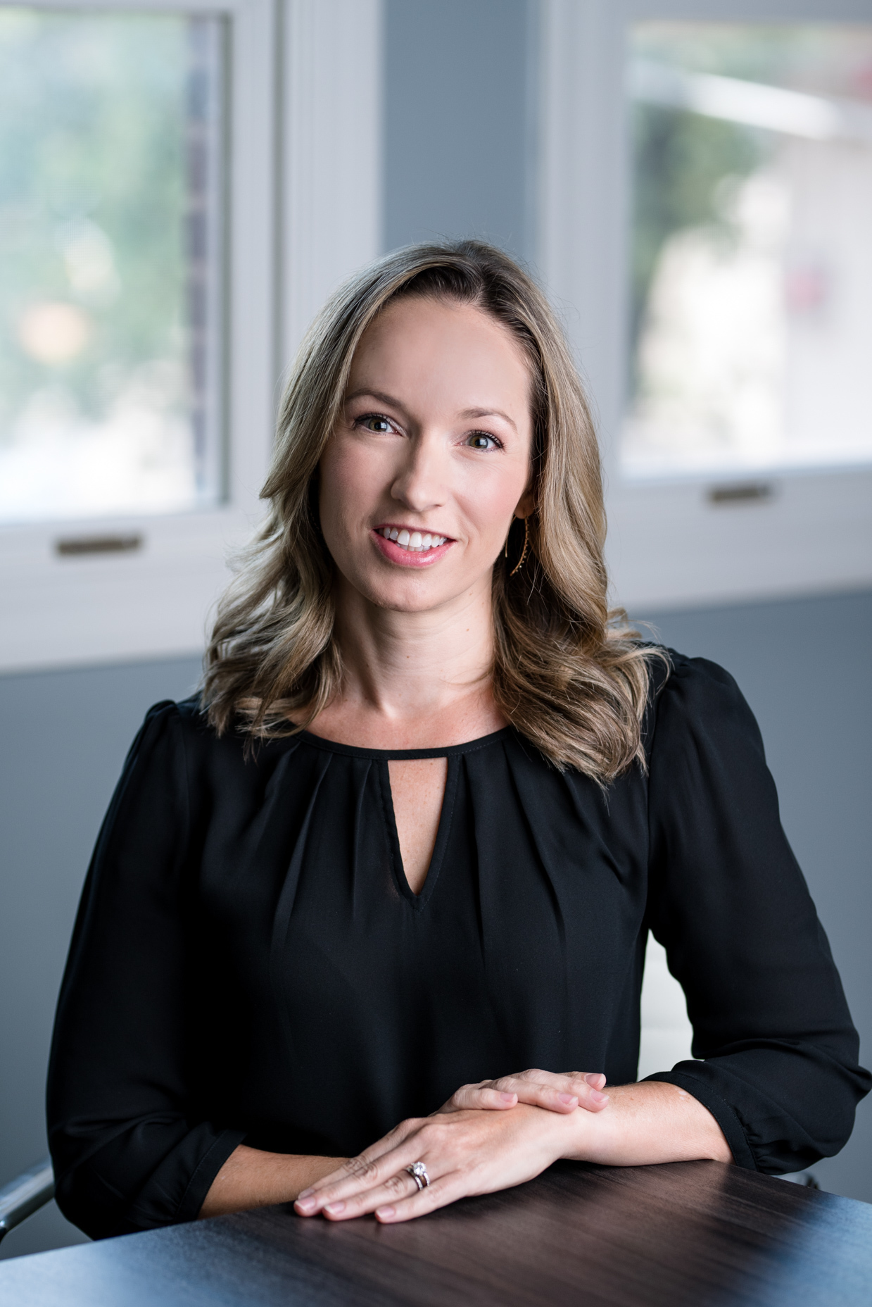 Acute care nurse practitioner Lisa Pomeroy, MSN, APRN, CPNP-AC, seated and smiling in front of a window in a black blouse.