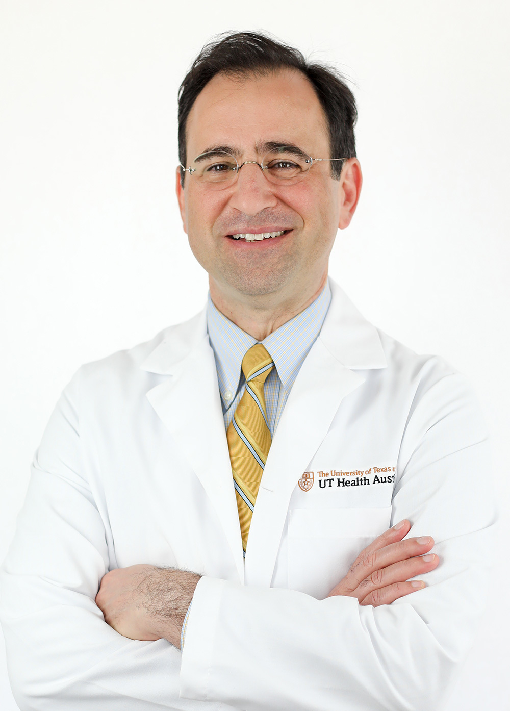 Neurologist David Paydarfar, MD, wearing a white coat and smiling in front of a white backdrop.