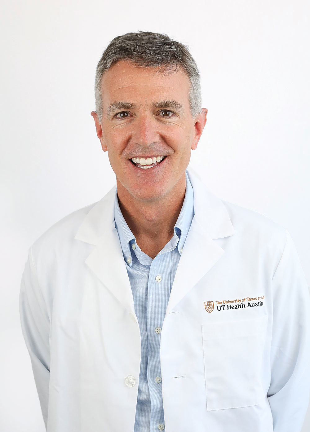 Dr. David Ring wearing a white coat and smiling in front of a white backdrop.