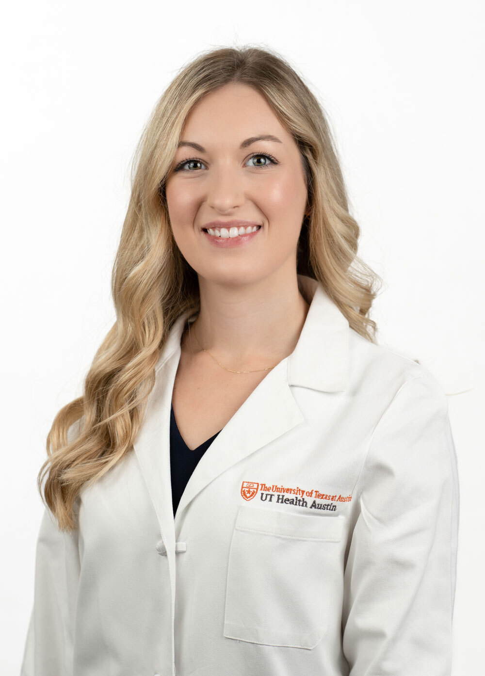Sarah Steffes is wearing a white coat and smiling at the camera.